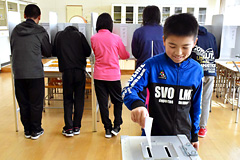 実際の投票箱に１票を投じる児童